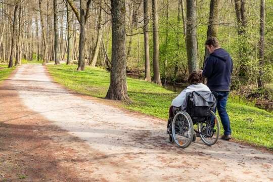 Accessible parks with person in a wheelchair with a companion walking with them. 